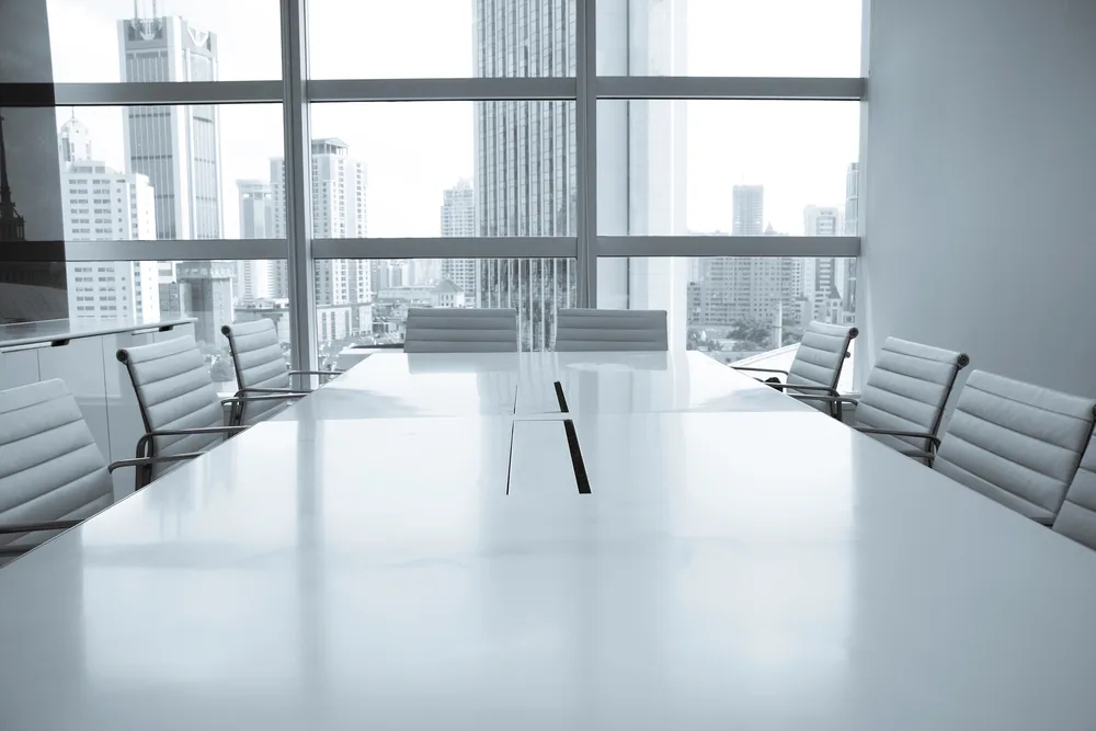 Sala de reuniones de oficina con mesa larga y sillas de cuero