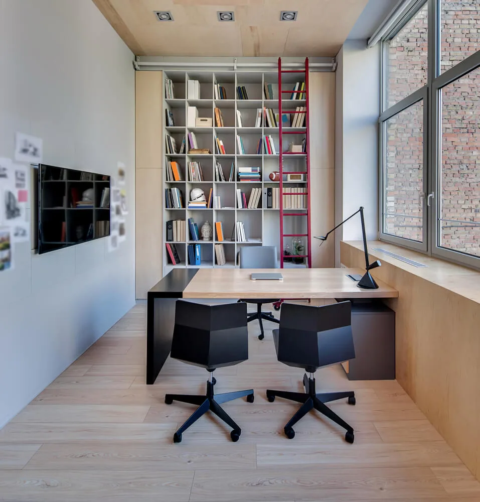 Despacho amueblado con mesa de madera, sillas y estantería de libros